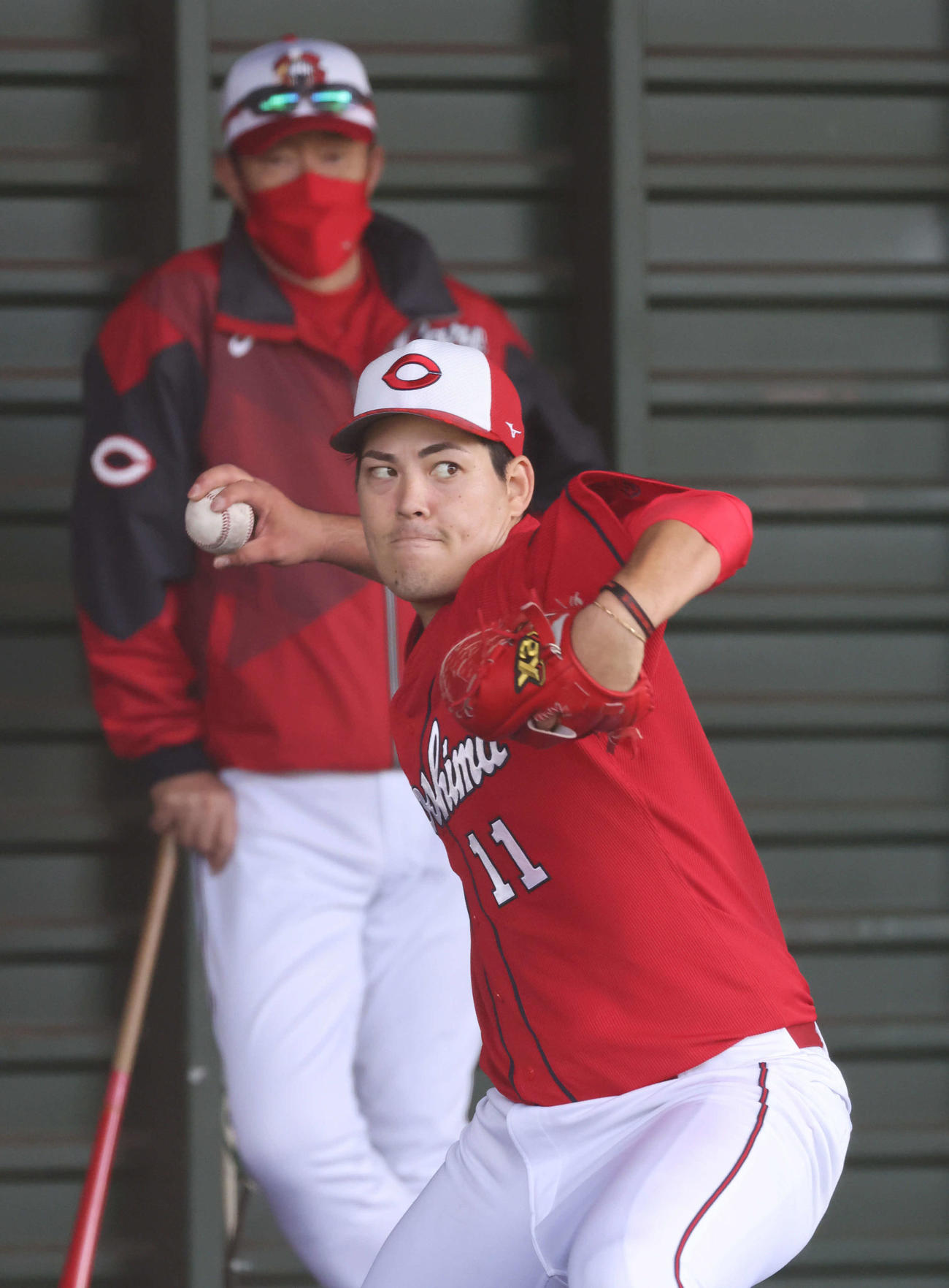 プロ野球広島沖縄キャンプ　ブルペンで投げ込む九里。後ろは佐々岡監督（撮影・加藤孝規）