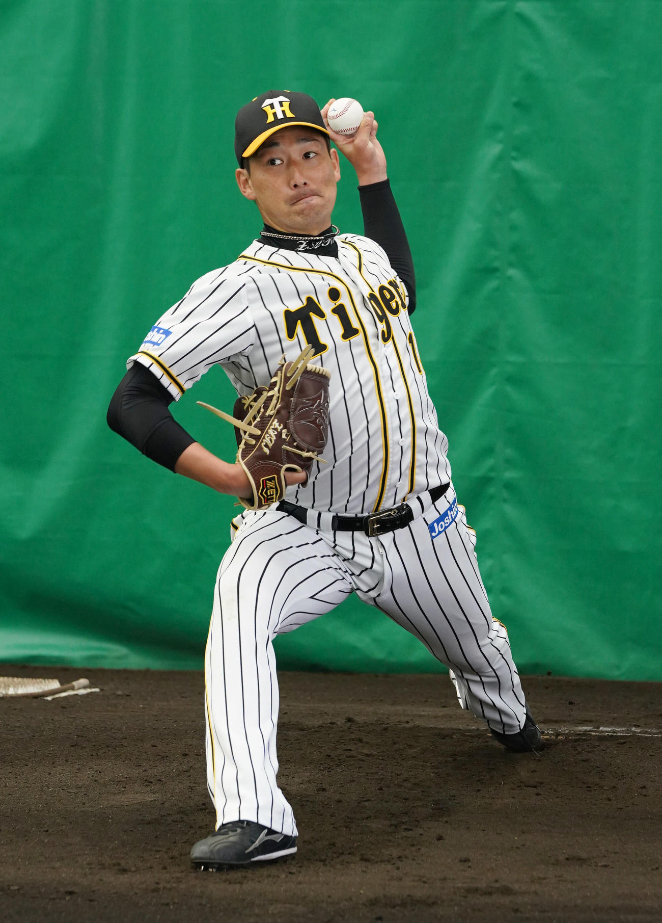 ブルペンで投球する阪神岩崎