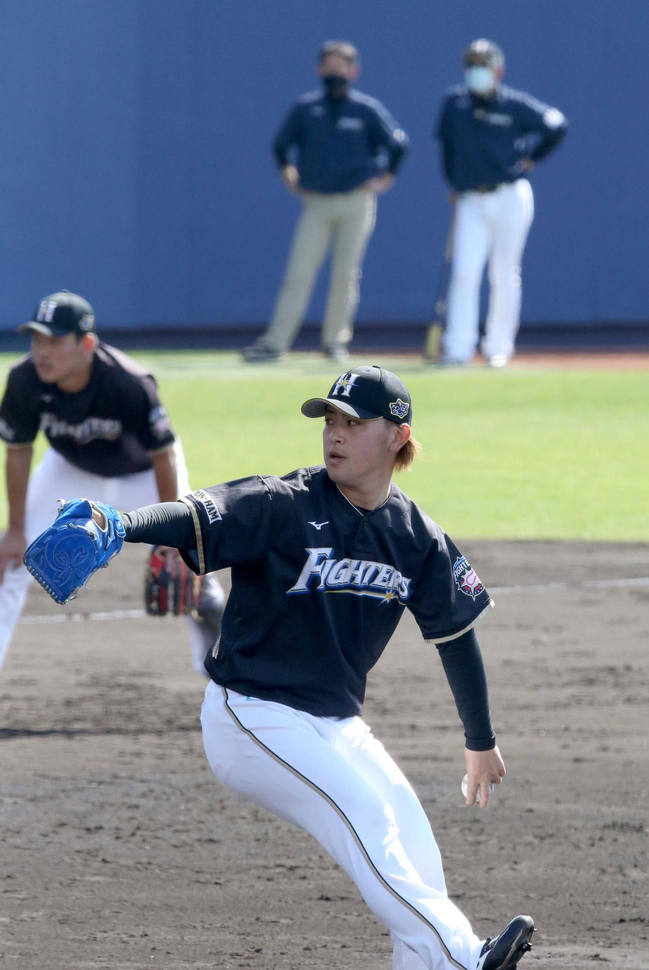 投内連携をする日本ハム河野。右奥は栗山監督（撮影・佐藤翔太）