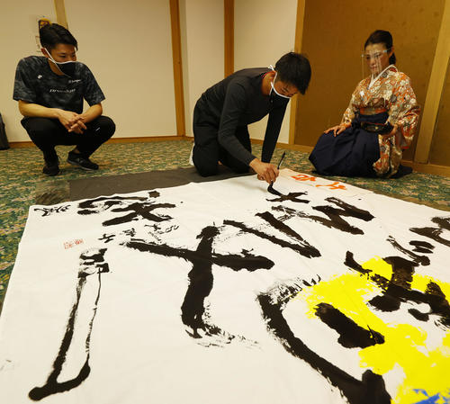 キャンプ休日に書道で今年の目標を書にしたためる中川颯（左）と山下。右は今井美恵子講師