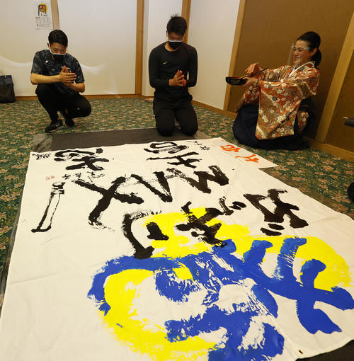 キャンプ休日に書道で今年の目標を書にしたためる中川颯（左）と山下。右は今井美恵子講師