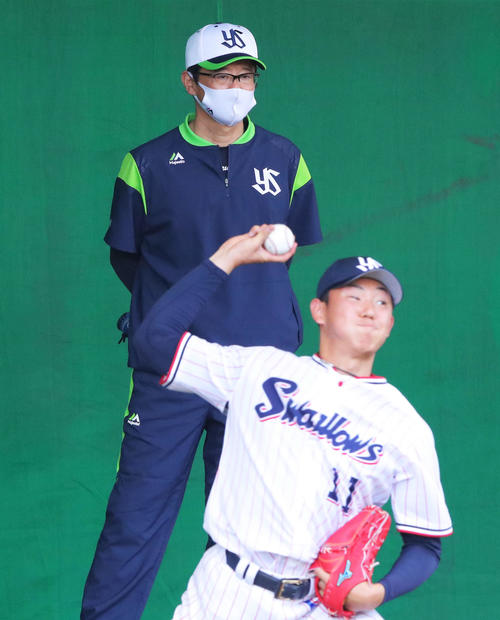 ブルペンでヤクルト奥川（手前）の投球を見つめる古田臨時コーチ（撮影・河田真司）