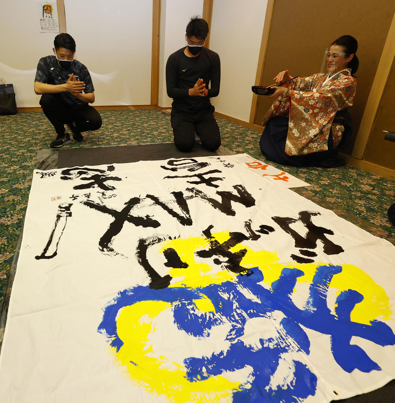 キャンプ休日に書道で今年の目標を書にしたためる中川颯（左）と山下。右は今井美恵子講師