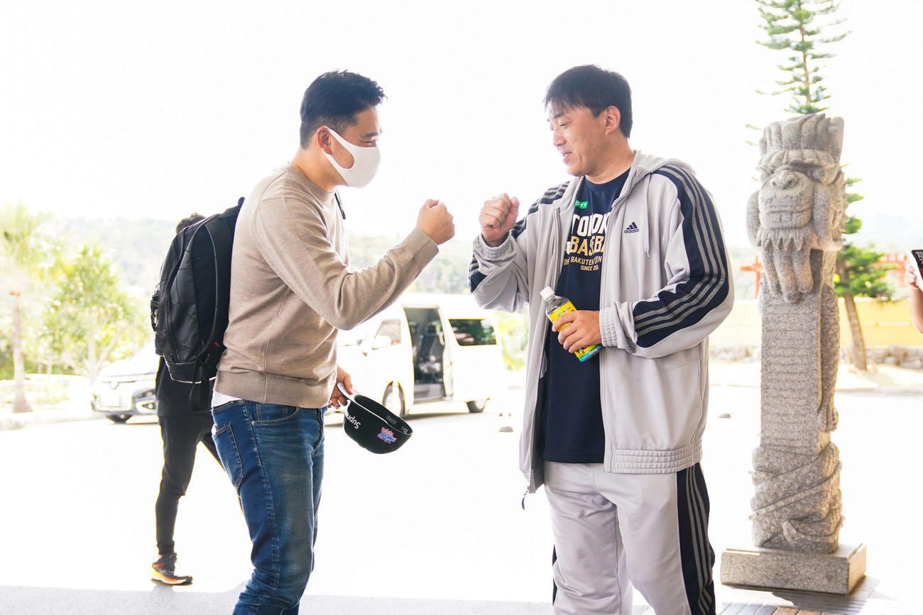 沖縄のチーム宿舎に到着した楽天田中将（左）は石井GM兼監督（右）とグータッチをする（球団提供）