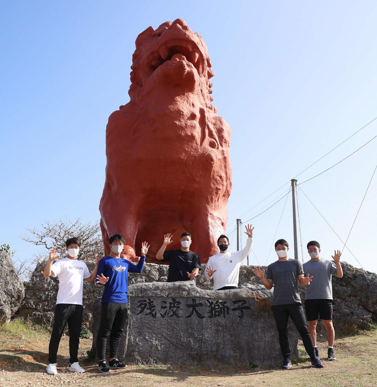 好天の屋外へ散歩に出かけ巨大シーサーと記念撮影する、左から中野、伊藤将、佐藤輝、佐藤蓮、栄枝、石井大（球団提供）