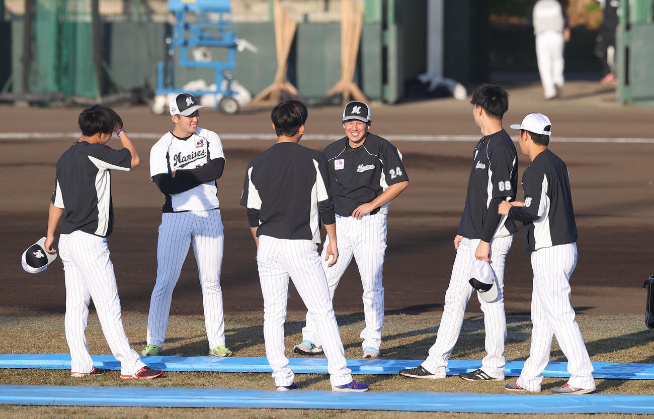 練習前、前日結婚を発表したロッテ東妻（中央）はナインと満面の笑顔をみせる（撮影・垰建太）
