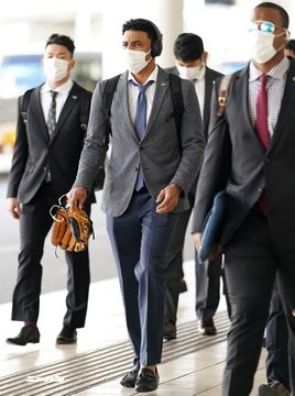 那覇空港に到着した巨人サンチェスはグラブを手に移動バスへ向かう