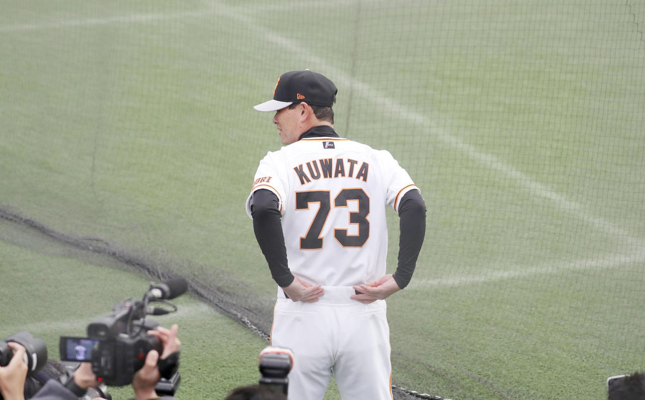 照れくさそうに報道陣に背番号73のユニホームを披露する桑田投手チーフコーチ補佐（撮影・狩俣裕三）