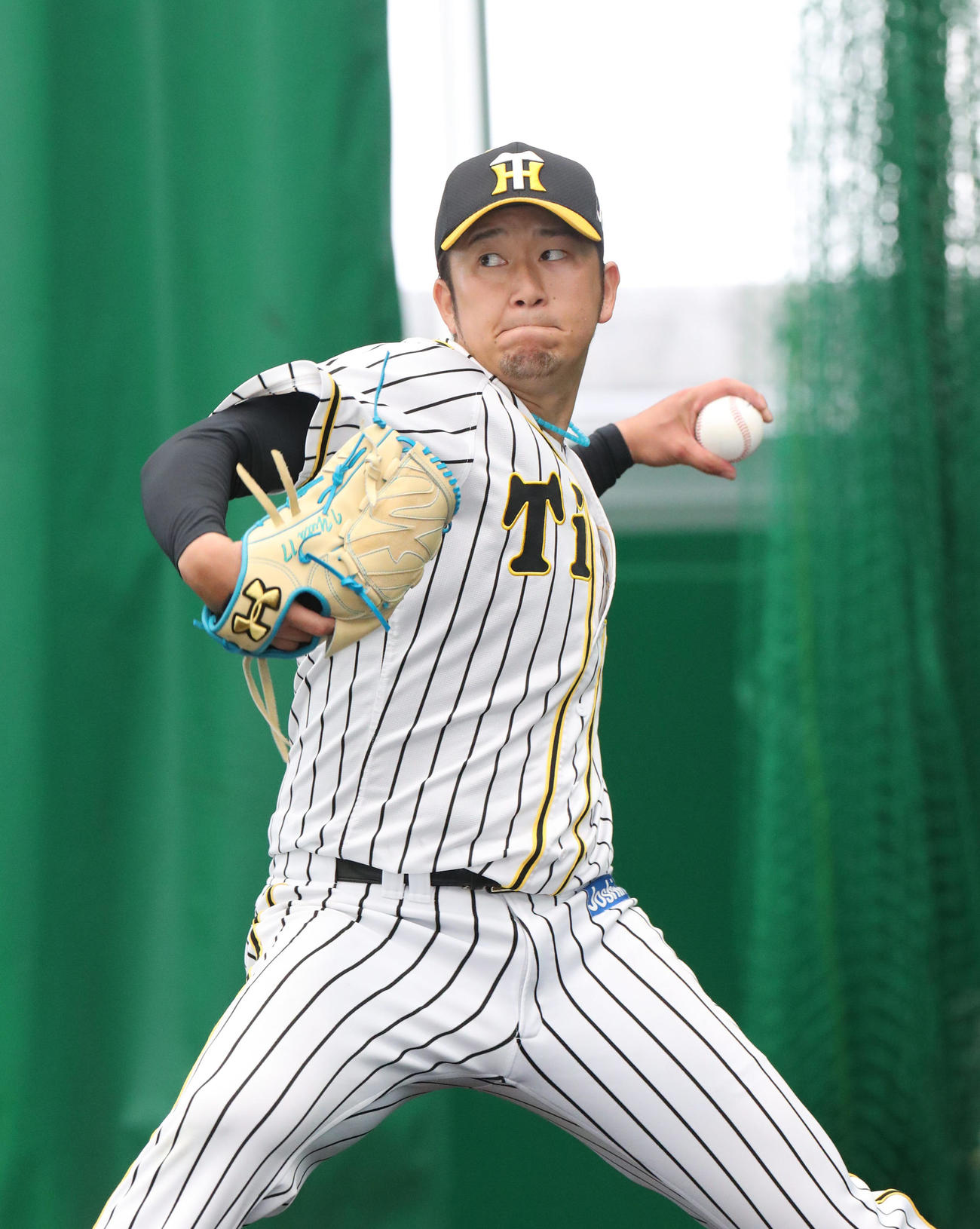 ブルペンで投球する阪神岩貞