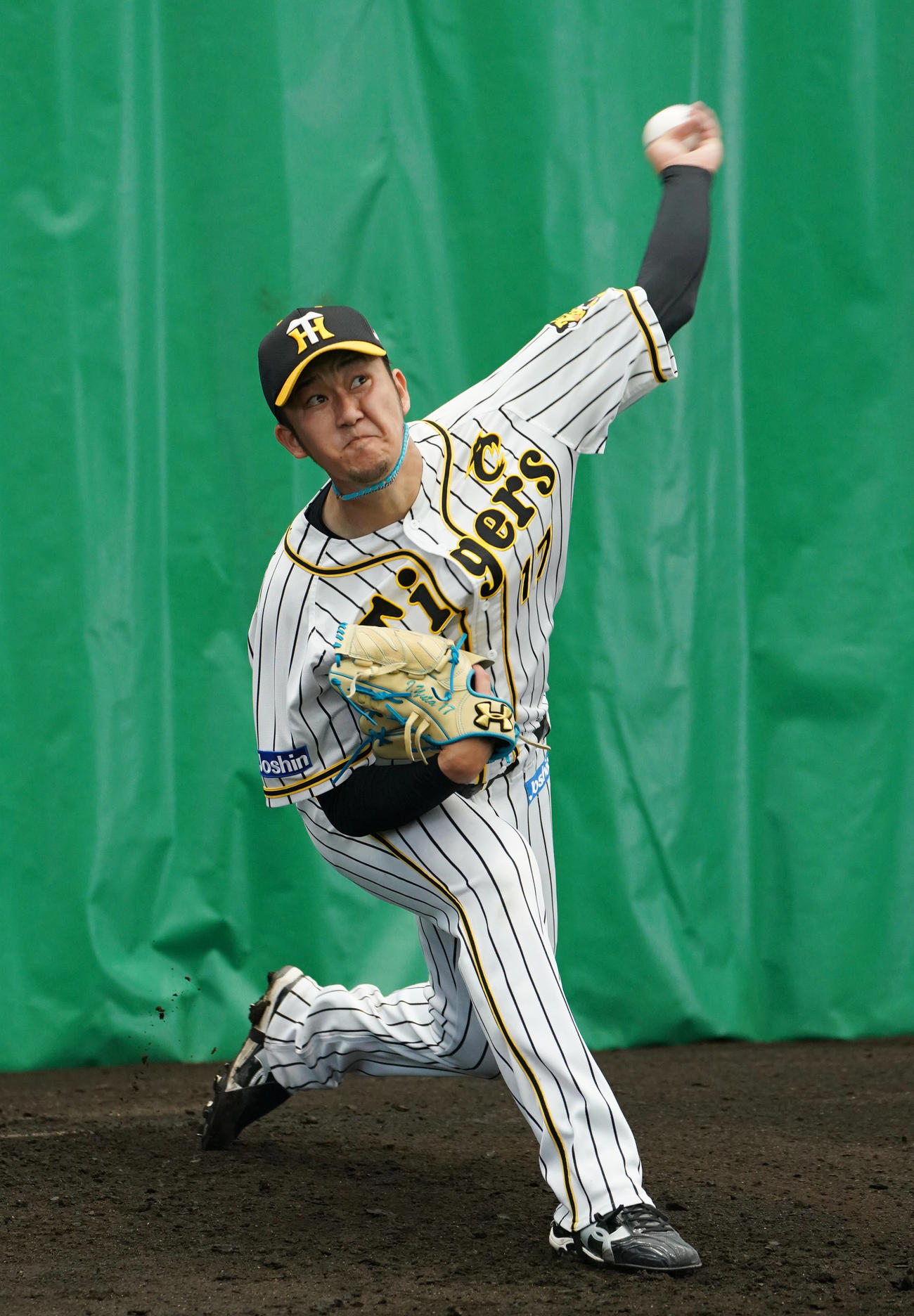 ブルペンで投球する阪神岩貞