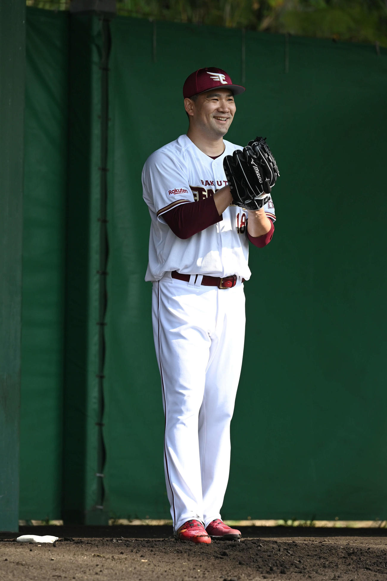 ブルペンで捕手に高めへ構えるように要求した楽天田中将は笑顔を見せる（撮影・山崎安昭）
