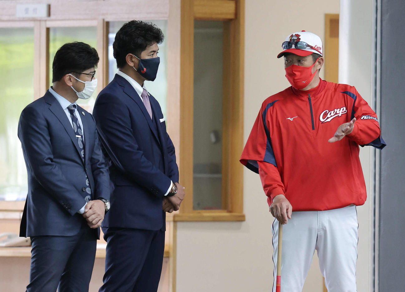 プロ野球広島沖縄キャンプ　佐々岡監督（右）と話す日本代表の稲葉監督（中央）。左は建山コーチ