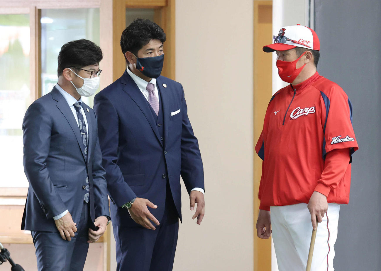 プロ野球広島沖縄キャンプ　佐々岡監督（右）と話す日本代表の稲葉監督（中央）。左は建山コーチ