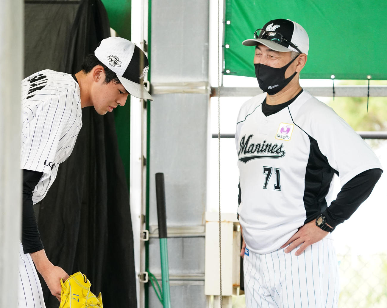 ブルペンで投球練習を終えたロッテ佐々木朗（左）は吉井投手コーチと言葉を交わす