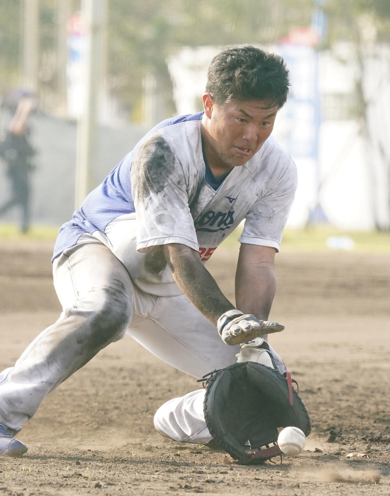泥まみれになりながらノックを受ける木下拓哉（撮影・森本幸一）＝2021年2月8日、沖縄県北谷町のAgreスタジアム北谷