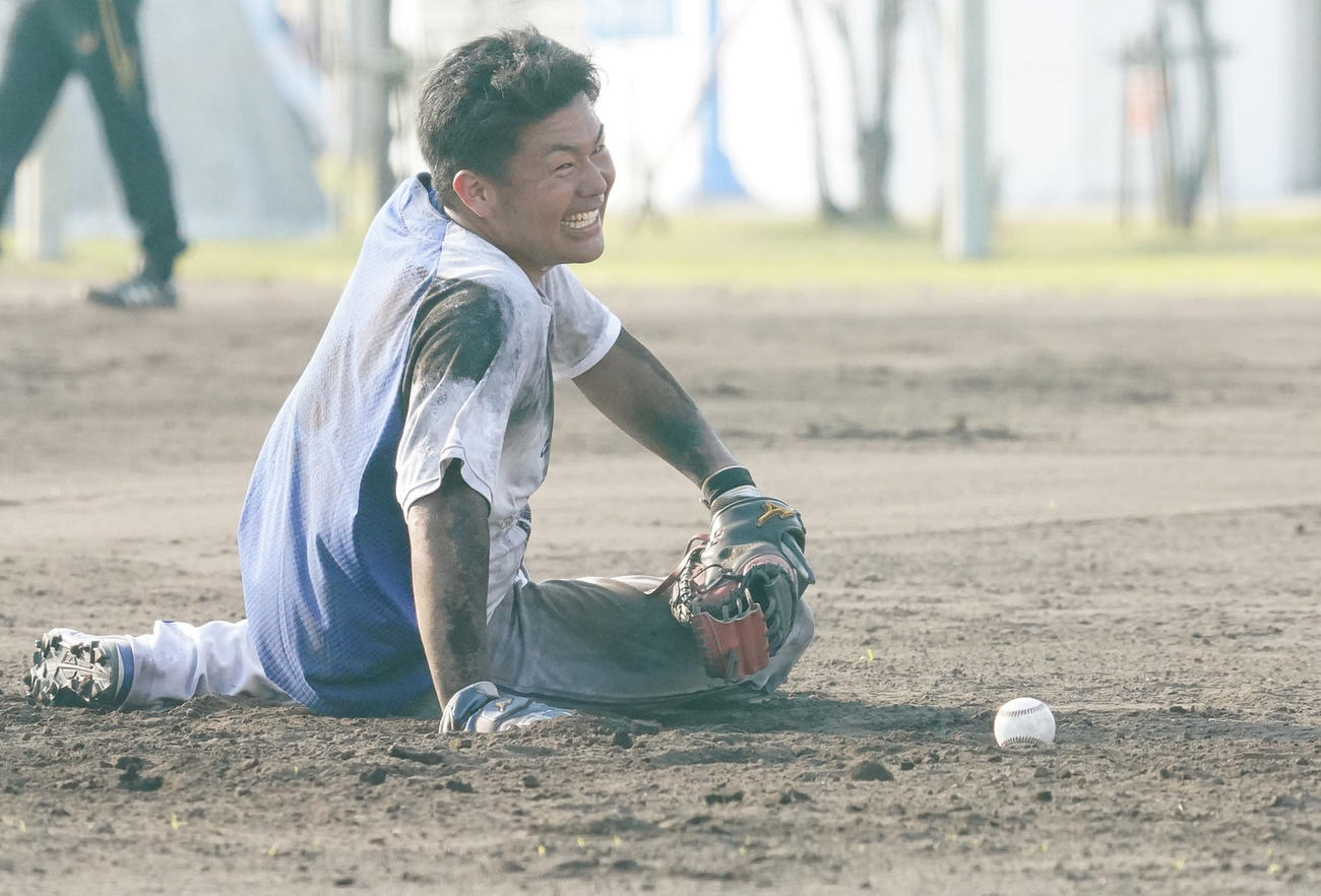 泥まみれになりながらノックを受ける木下拓哉（撮影・森本幸一）＝2021年2月8日、沖縄県北谷町のAgreスタジアム北谷