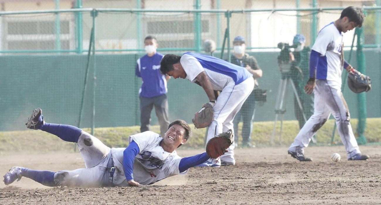 泥まみれになりながらノックを受ける加藤匠馬（左）（後方・右から郡司裕也、木下拓哉）（撮影・森本幸一）＝2021年2月8日、沖縄県北谷町のAgreスタジアム北谷
