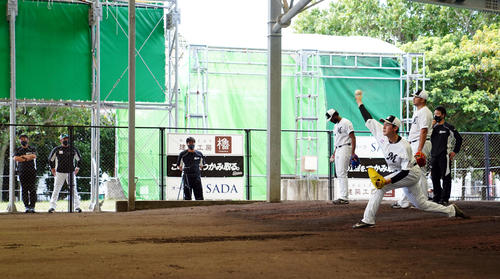 井口監督（左から2人目）が見つめる中ブルペンで投球練習するロッテ佐々木朗（手前）