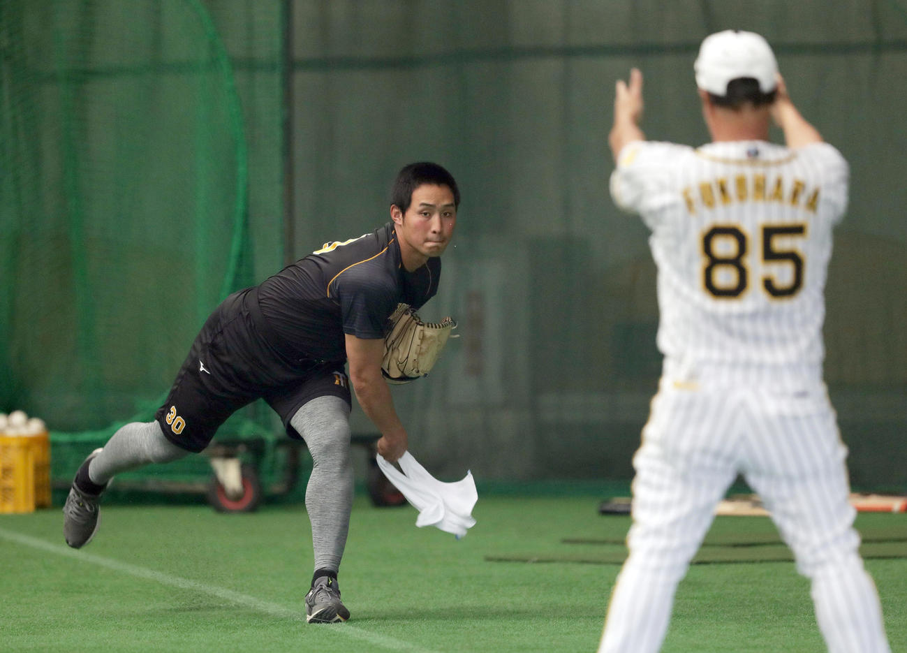 タオルを使ってシャドーピッチングを繰り返す阪神佐藤蓮。手前は指導する福原コーチ（撮影・前田充）