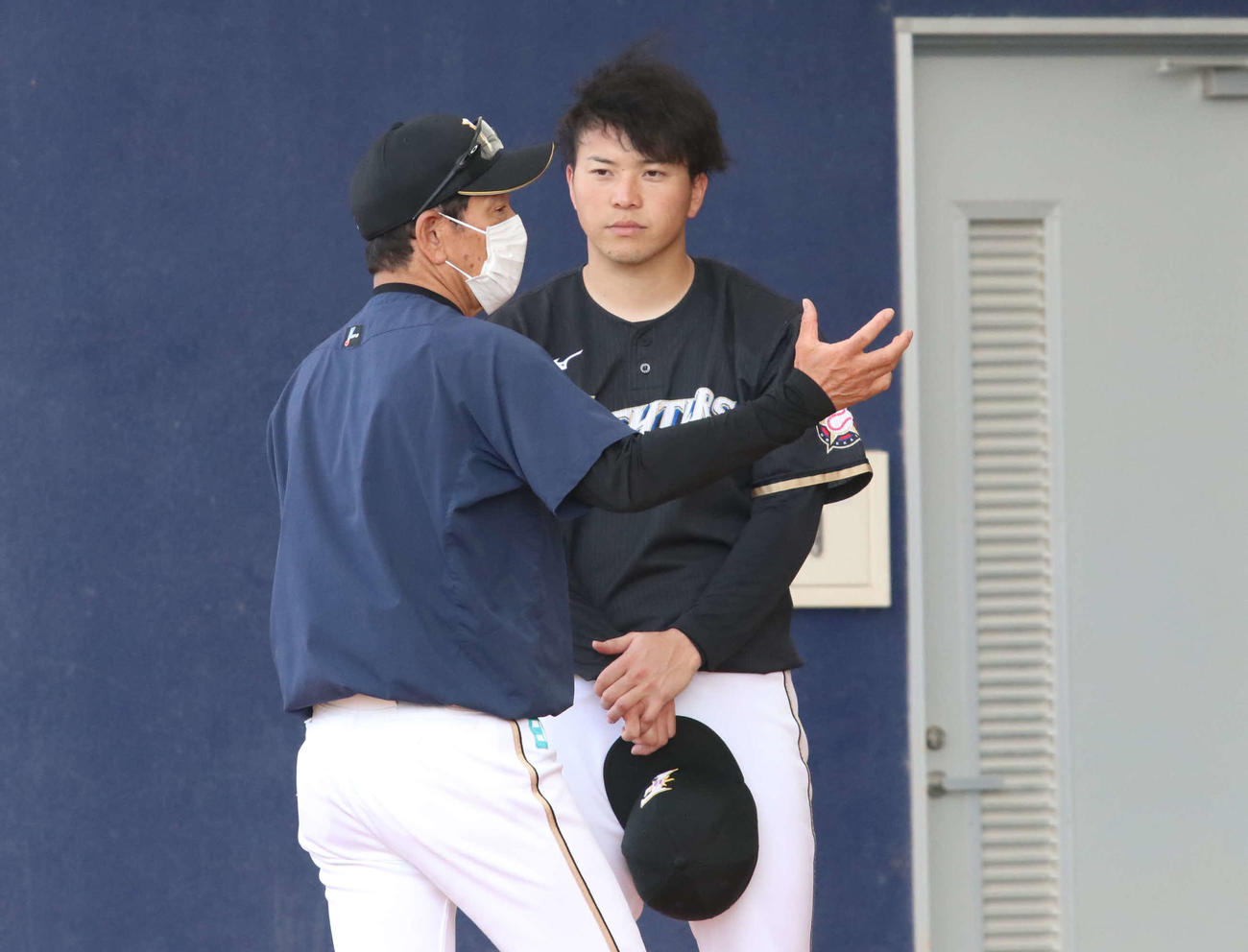 真剣な表情で栗山監督（左）の話を聞く日本ハム生田目（撮影・山崎純一）