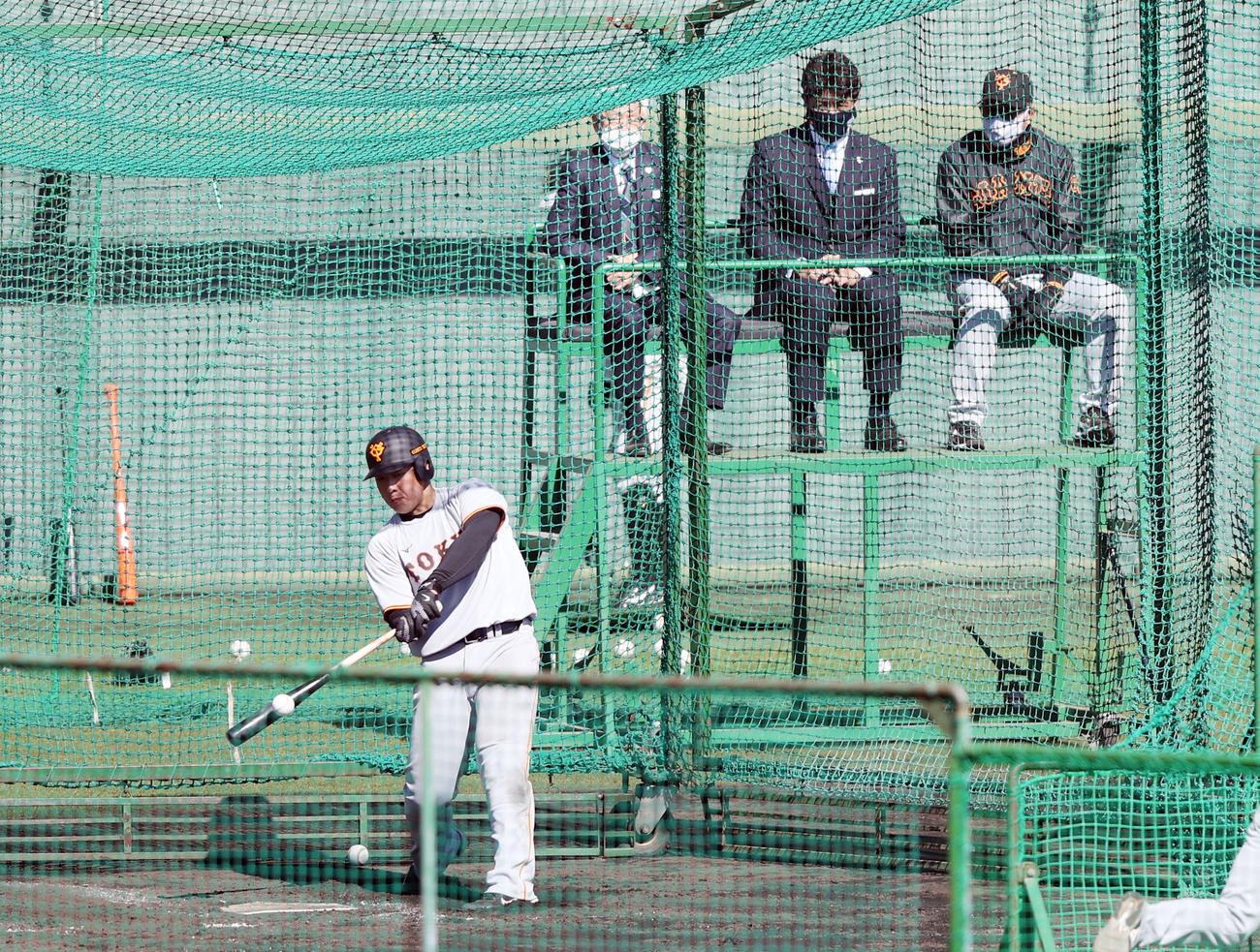 原監督（右）と稲葉監督（中央）に見守られながらフリー打撃を行う岡本和（撮影・狩俣裕三）