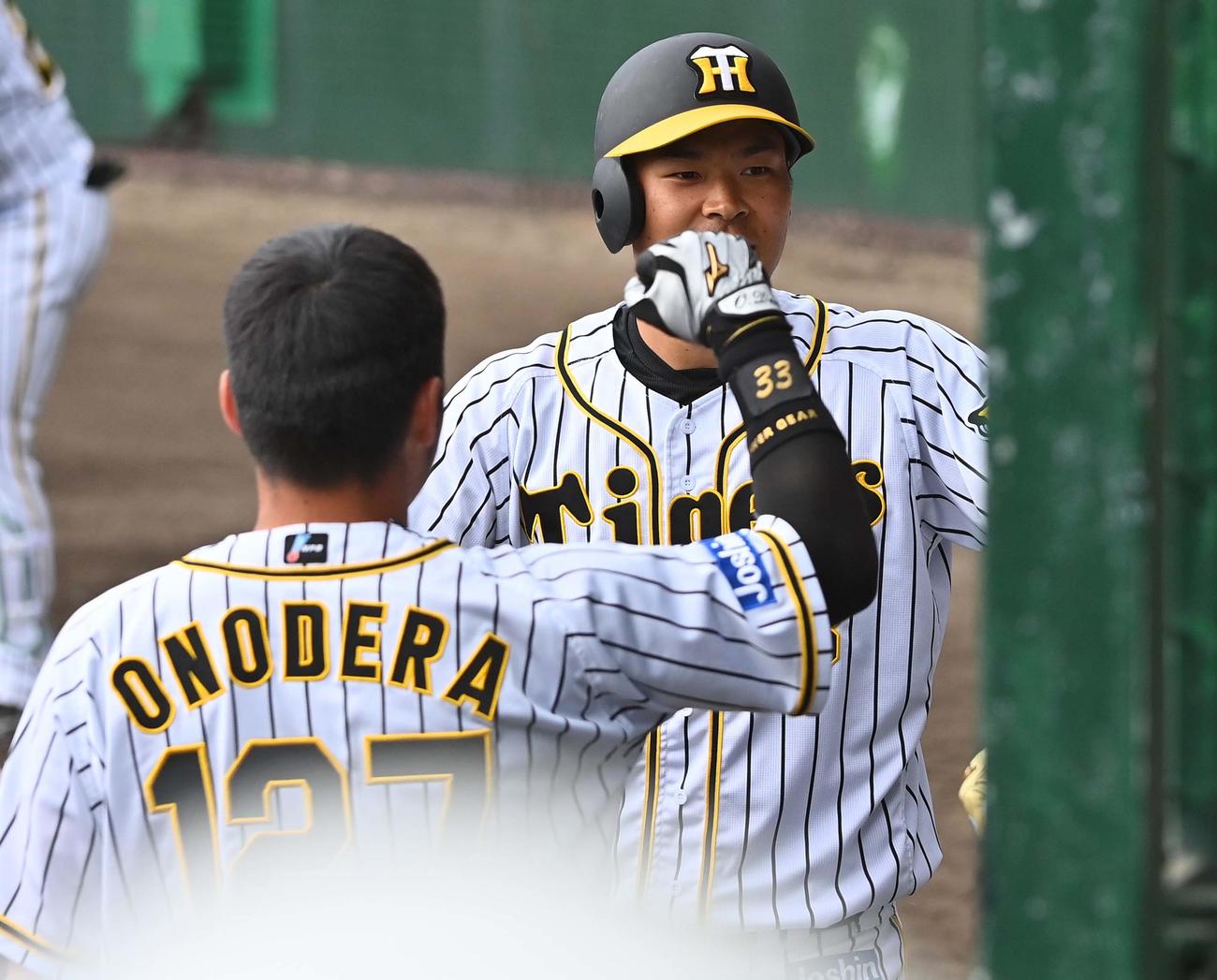 阪神対日本ハム　5回裏阪神無死一塁、右越えに2点本塁打を放ちナインの出迎えを受ける佐藤輝（撮影・上田博志）