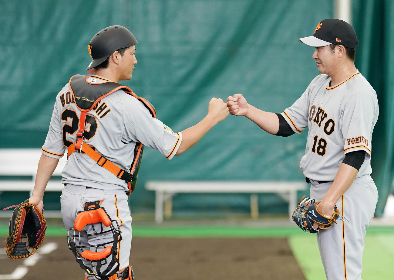 ブルペン投球後、巨人捕手小林（左）とタッチをかわす菅野（撮影・江口和貴）
