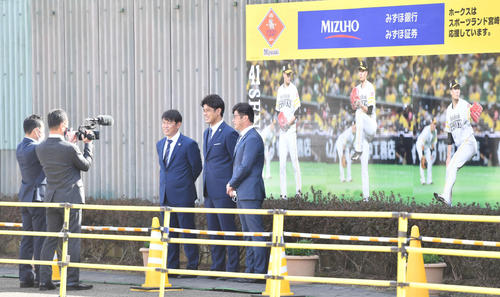 千賀の連続写真のパネルの前で記念撮影する（中央左から）侍ジャパン・井端コーチ、稲葉監督、建山投手コーチ（撮影・岩下翔太）