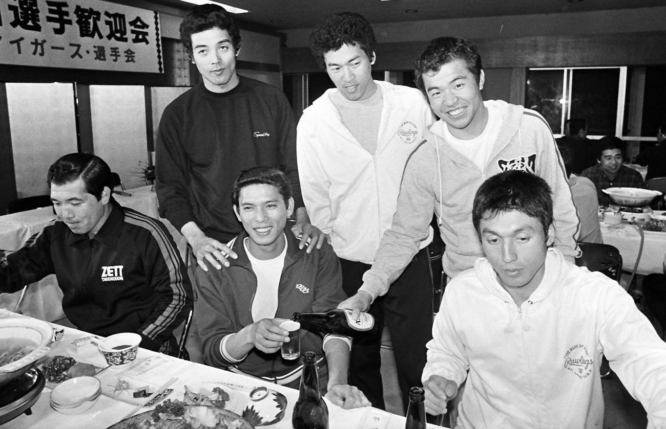 79年2月10日、入団発表後、高知入りした小林繁（中央）は「新入団選手歓迎会」に出席し、江本孟紀（左から2人目）、若菜嘉晴（同4人目）、掛布雅之（同5人目）らに囲まれ笑顔を見せる。右端は真弓明信