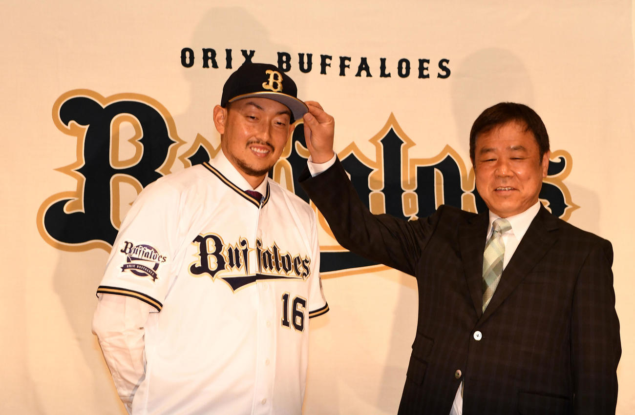 オリックス入団会見を行った平野（左）は福良GMから笑顔で帽子をかぶせてもらう（撮影・前岡正明）