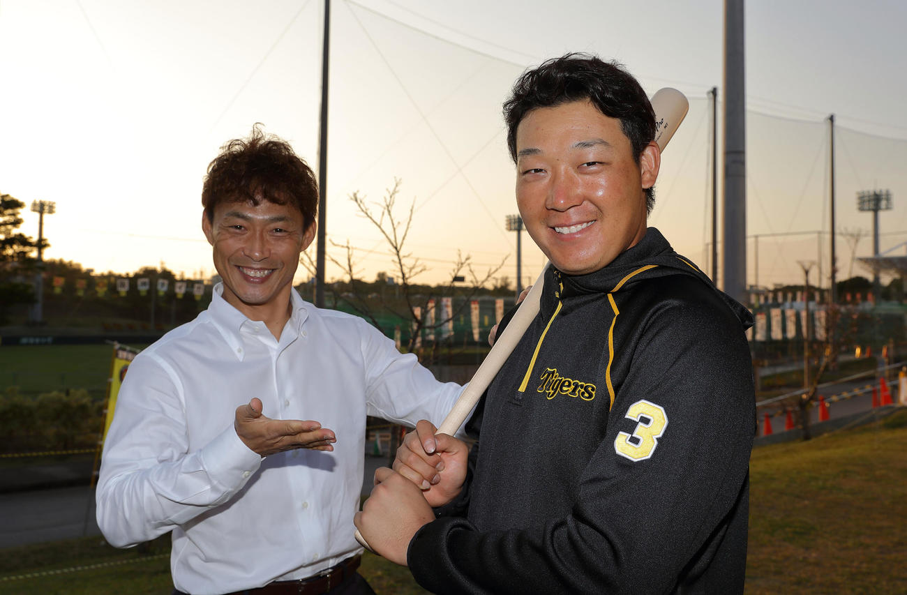 夕焼けに染まる宜野座で笑顔を見せる阪神大山（右）と本紙評論家の桧山進次郎氏（撮影・前田充）※撮影時のみマスクを外しています