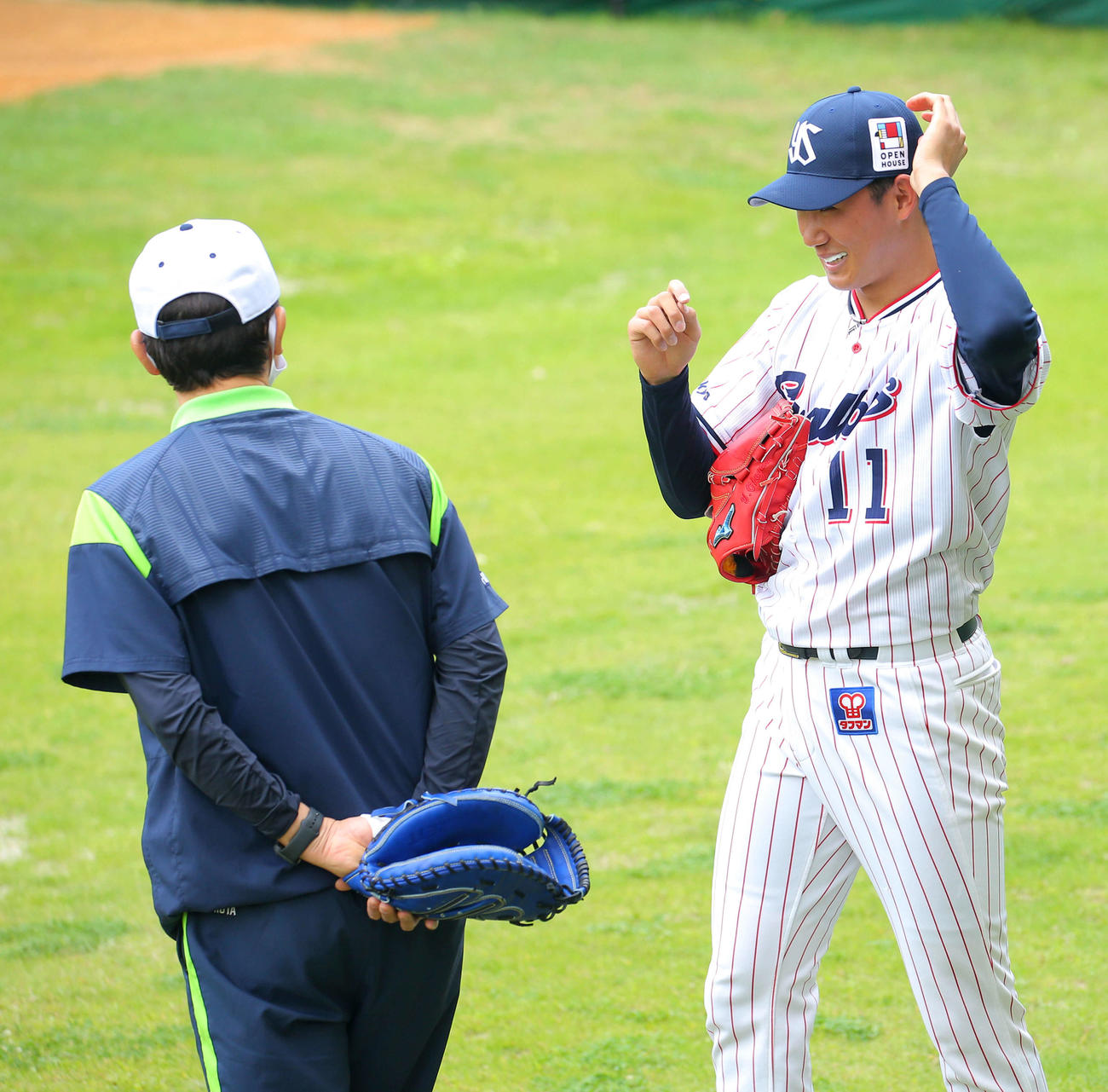 ブルペンで球を受けた古田臨時コーチ（左）と言葉を交わすヤクルト奥川　（撮影・河田真司）