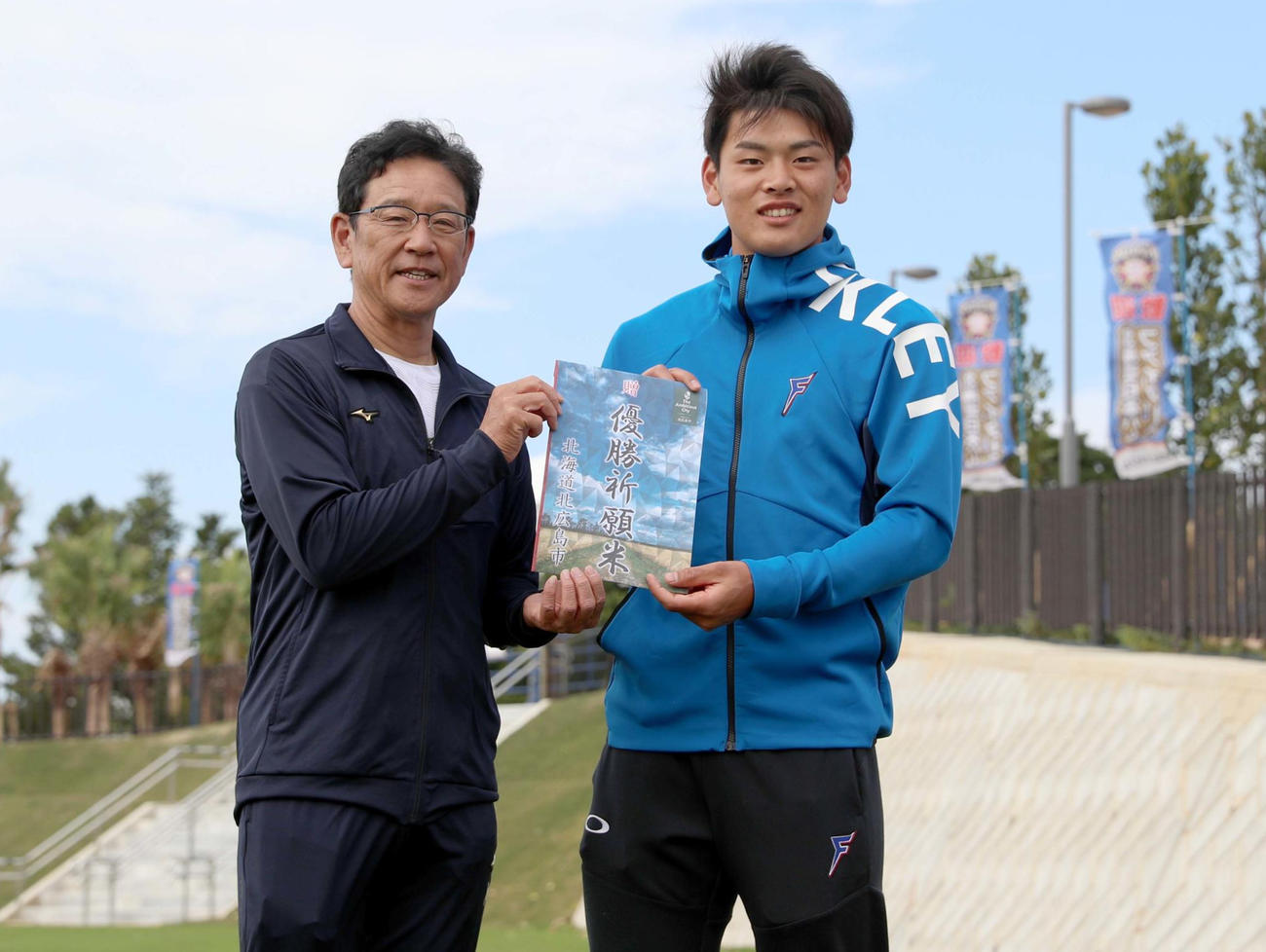 上野北広島市長から贈られた「優勝祈願米」の目録を手に笑顔で撮影に応じる日本ハム栗山監督（左）と野村（撮影・佐藤翔太）