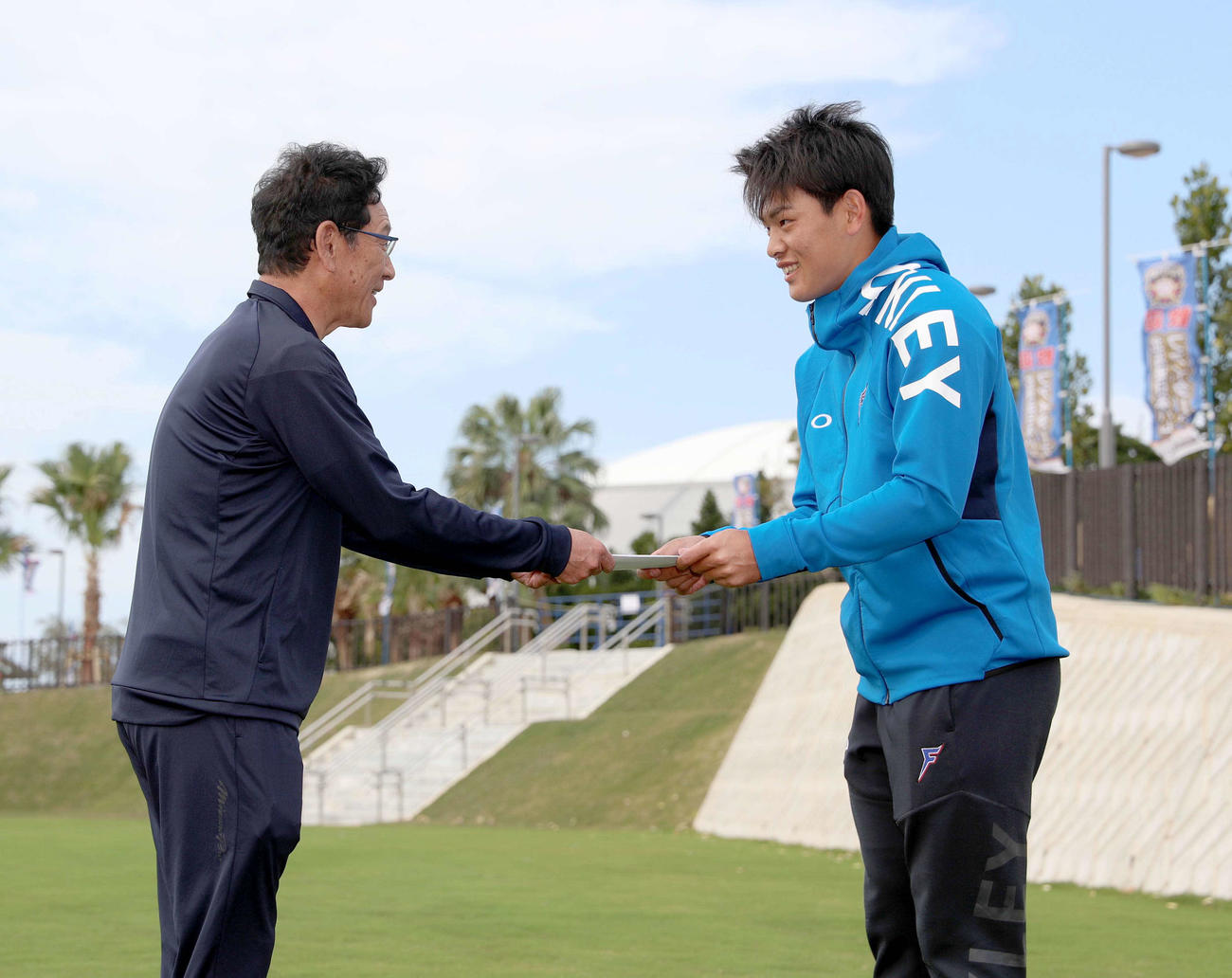 上野北広島市長に代わって「優勝祈願米」の目録を日本ハム栗山監督（左）に手渡す野村（撮影・佐藤翔太）