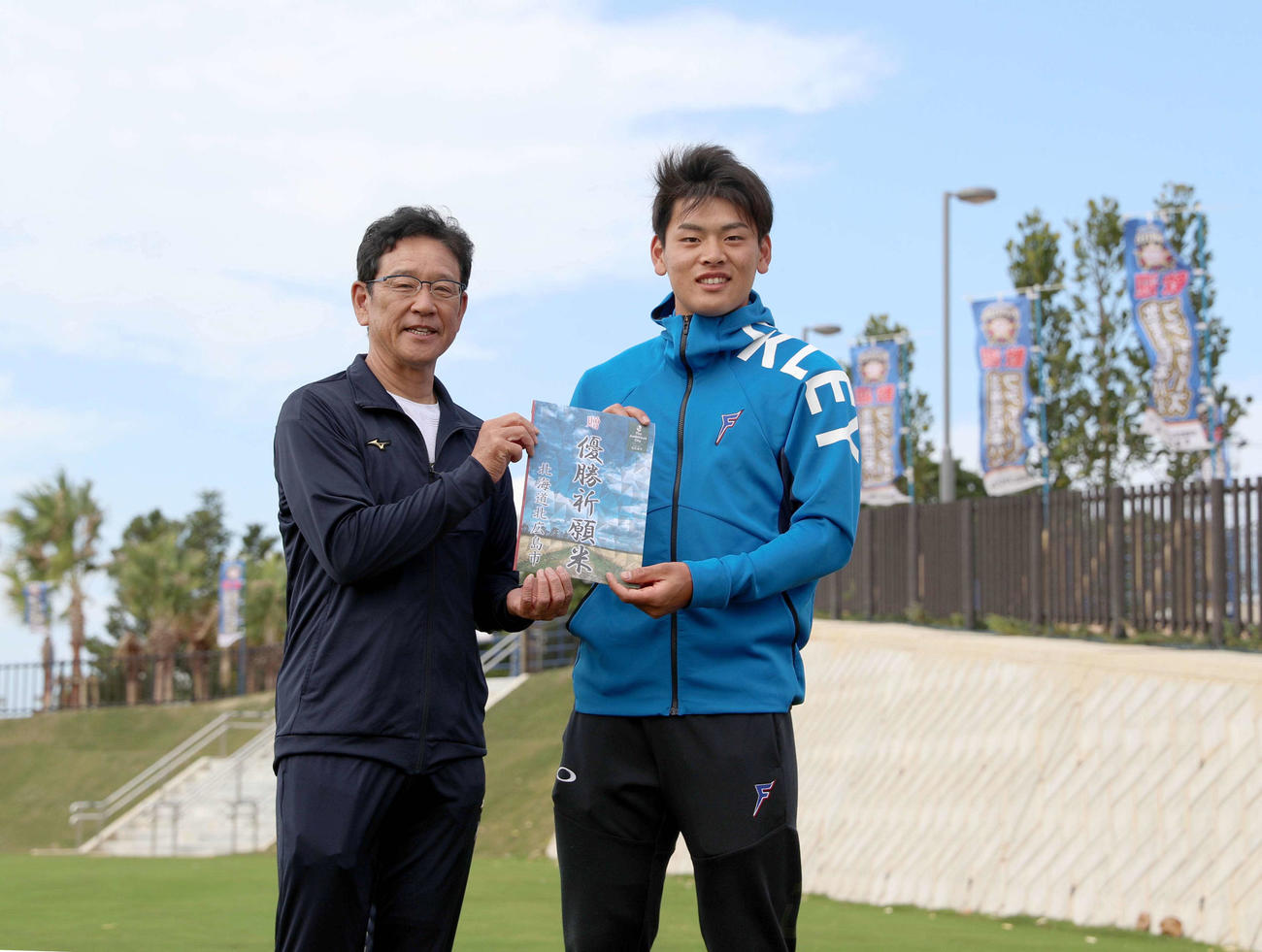 上野北広島市長から贈られた「優勝祈願米」の目録を手に笑顔で撮影に応じる日本ハム栗山監督（左）と野村（撮影・佐藤翔太）