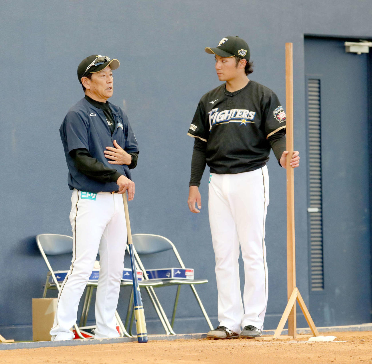 2月6日、ブルペンでの投球を終え日本ハム栗山監督（左）と会話をする伊藤