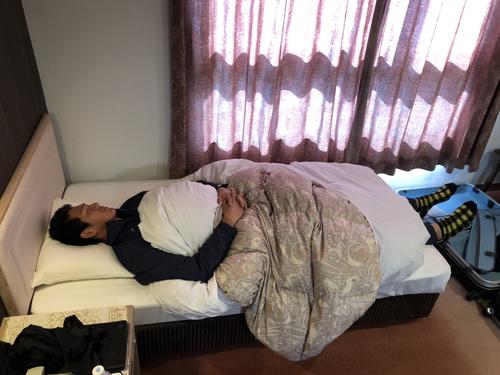 宿舎のベッドに寝る秋広（球団提供）