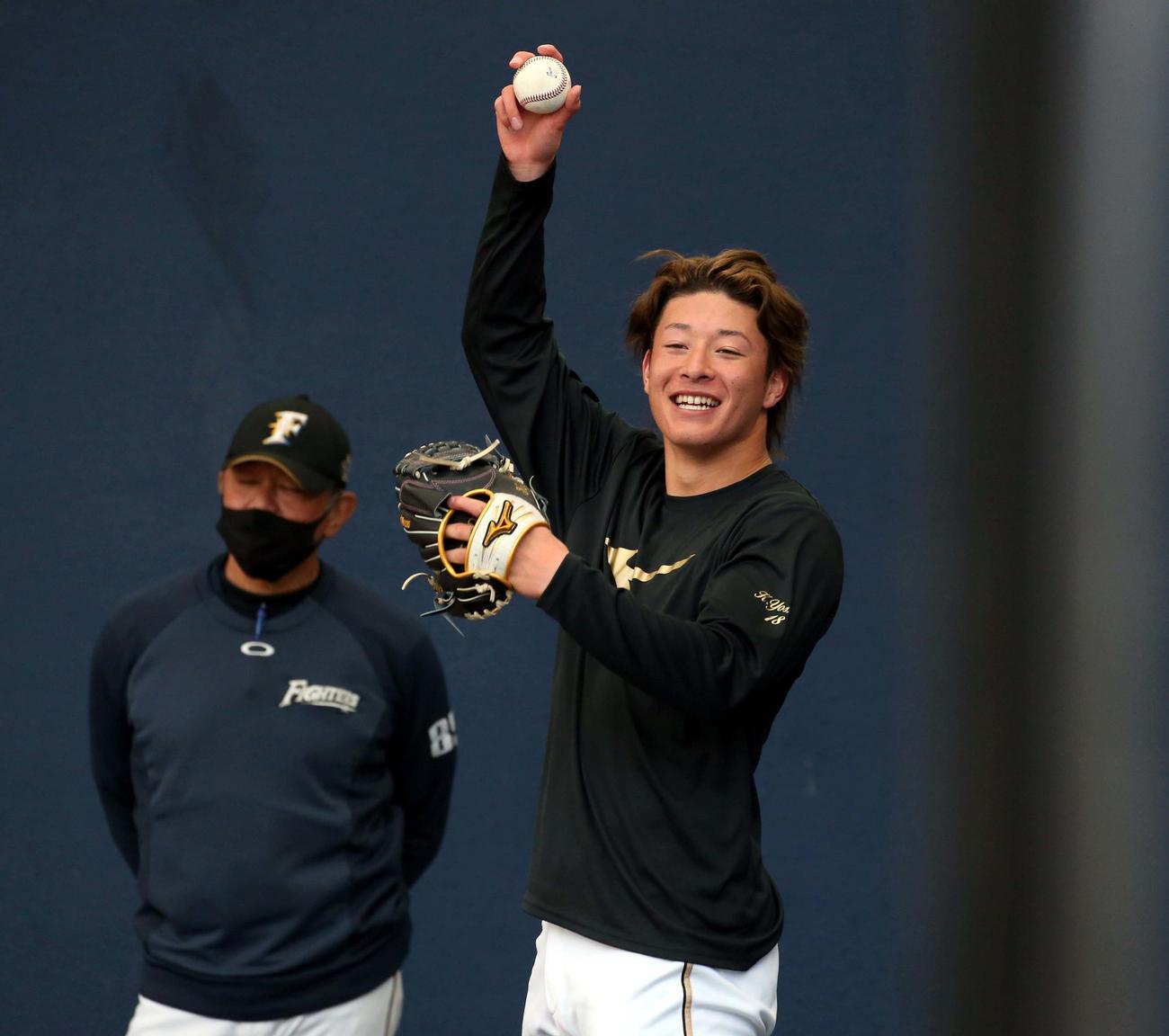ブルペンで投球し笑顔を見せる日本ハム吉田（撮影・黒川智章）　　　