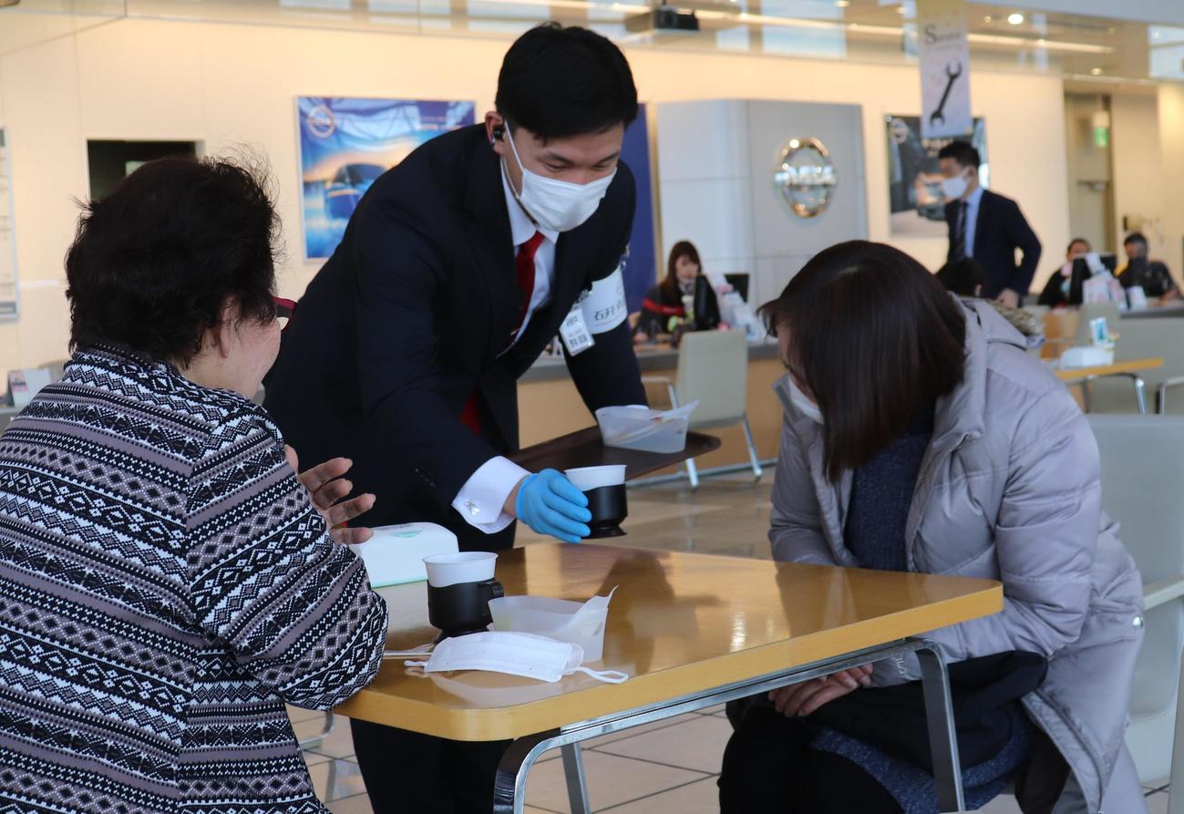来客した人に飲み物を出す茨城日産・野本（中）（撮影・古川真弥）