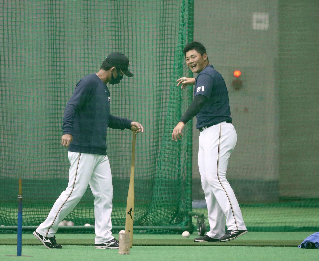 日本ハム小笠原ヘッドコーチ兼打撃コーチ（左）から指導を受け笑顔の清宮（撮影・黒川智章）　　　