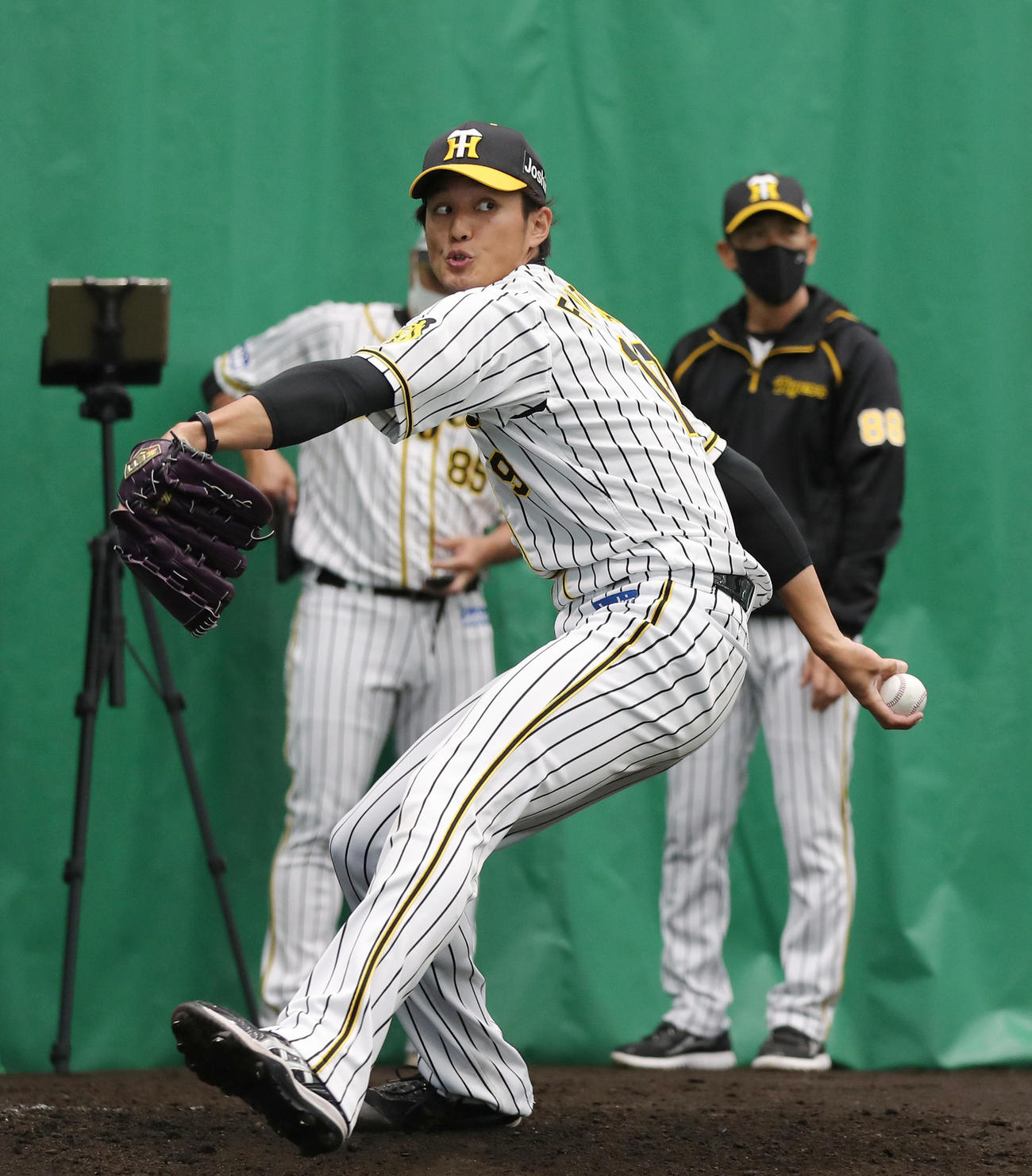ブルペンで阪神矢野監督（後方右）が見つめる前で投球する藤浪（撮影・前田充）