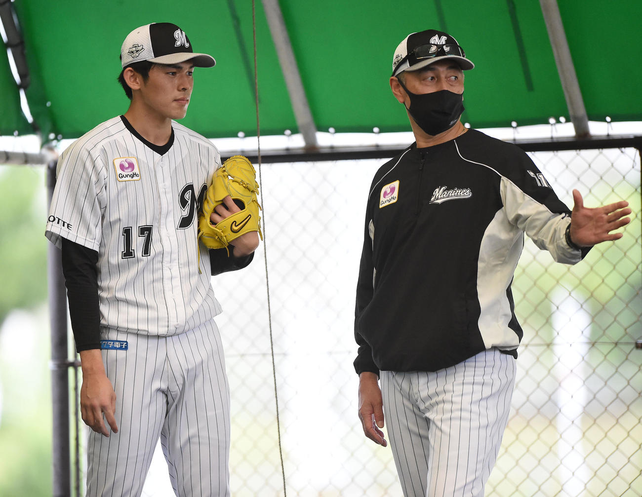 ブルペンで投球を終え言葉を交わすロッテ佐々木朗（左）と吉井投手コーチ