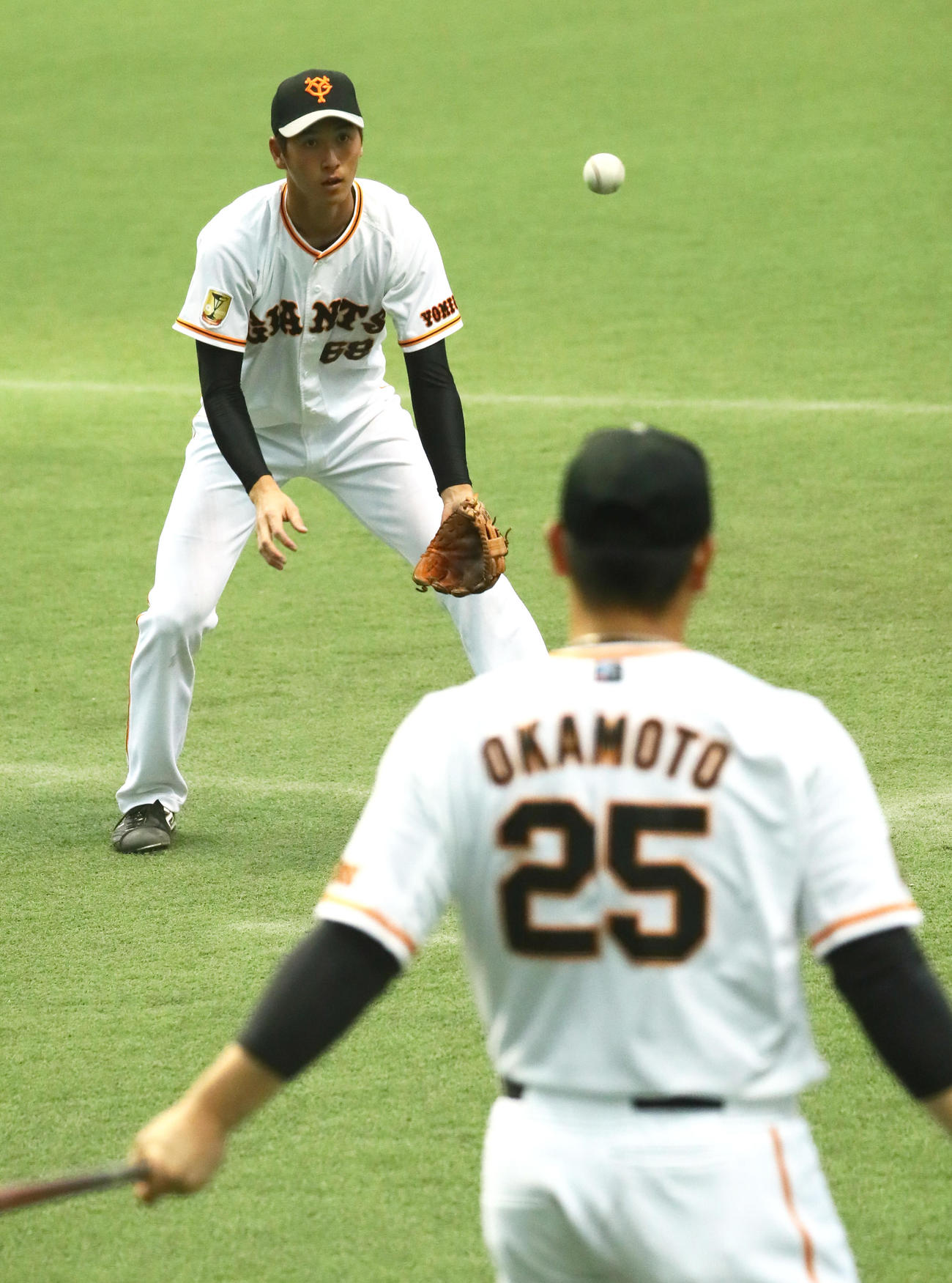巨人岡本和（手前）とペッパーを行う秋広（撮影・足立雅史）