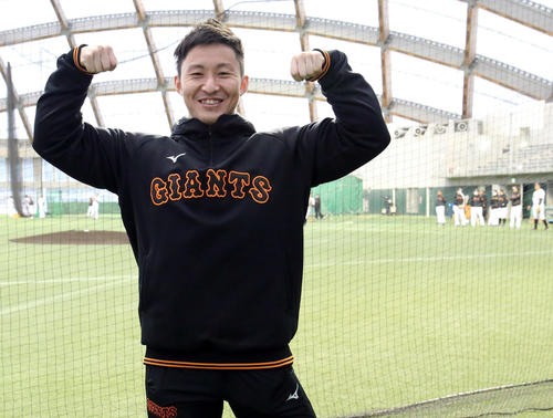 日本選手権9連覇の実績を誇るボディービルダー鈴木氏が球団スタッフとして招かれた。巨人の選手たちが練習する中、得意ポーズを決める（撮影・狩俣裕三）