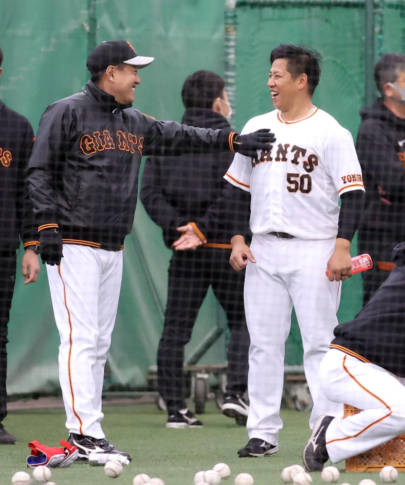 1軍に合流し、原監督（左）から大胸筋を触られて笑顔を見せる戸根（撮影・狩俣裕三）