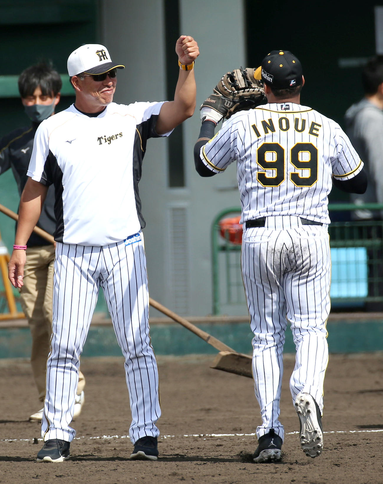 阪神井上ヘッドコーチ（左）のユニホームを着てシートノックしたマルテは笑顔でタッチする（撮影・上山淳一）