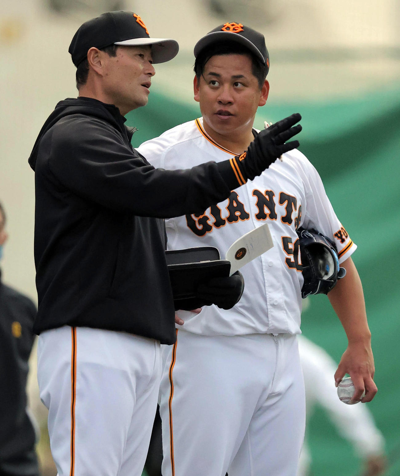 室内ブルペンで投げ終えた戸根（右）にアドバイスする桑田投手チーフコーチ補佐