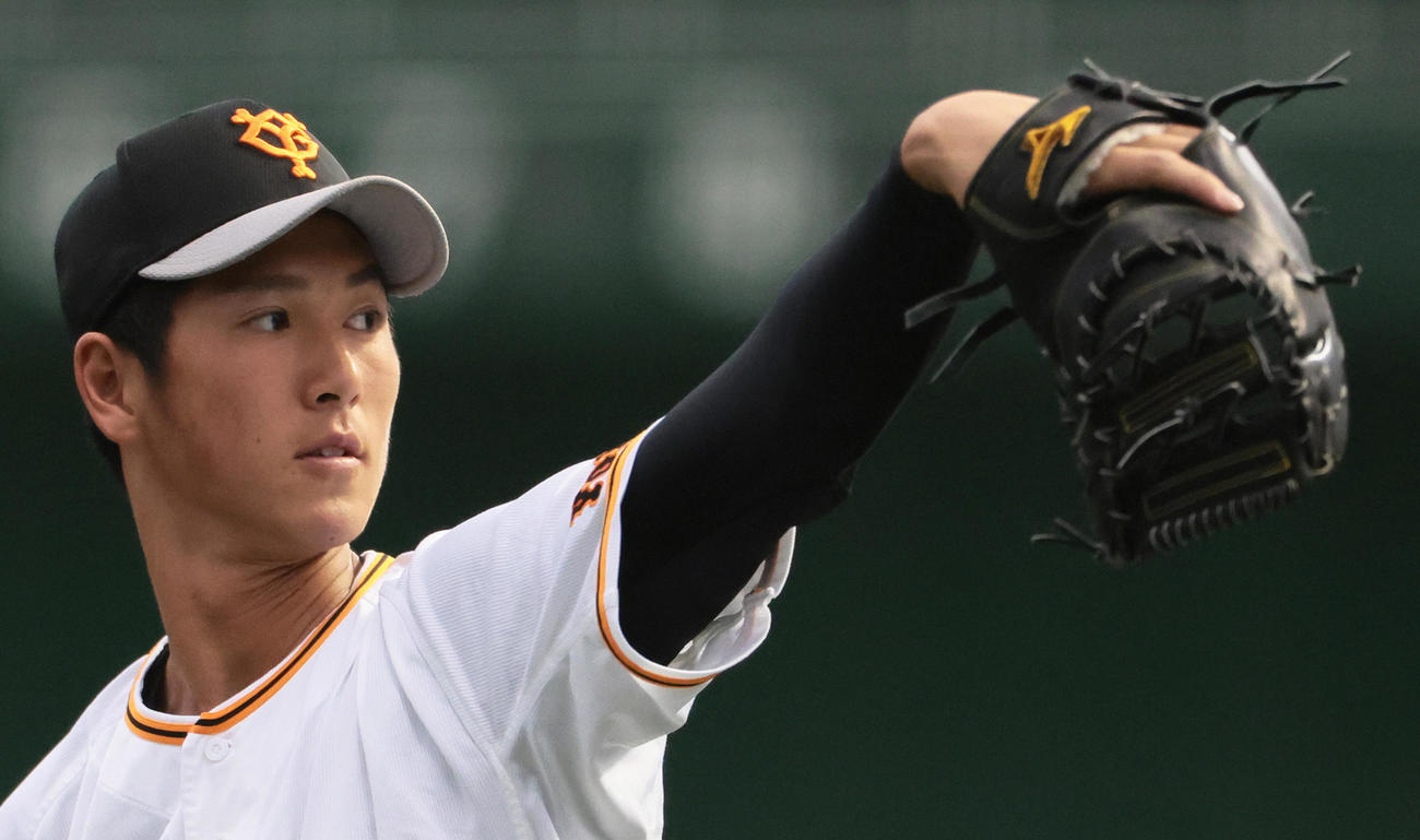 ファーストミットを手にキャッチボールする巨人秋広（撮影・足立雅史）