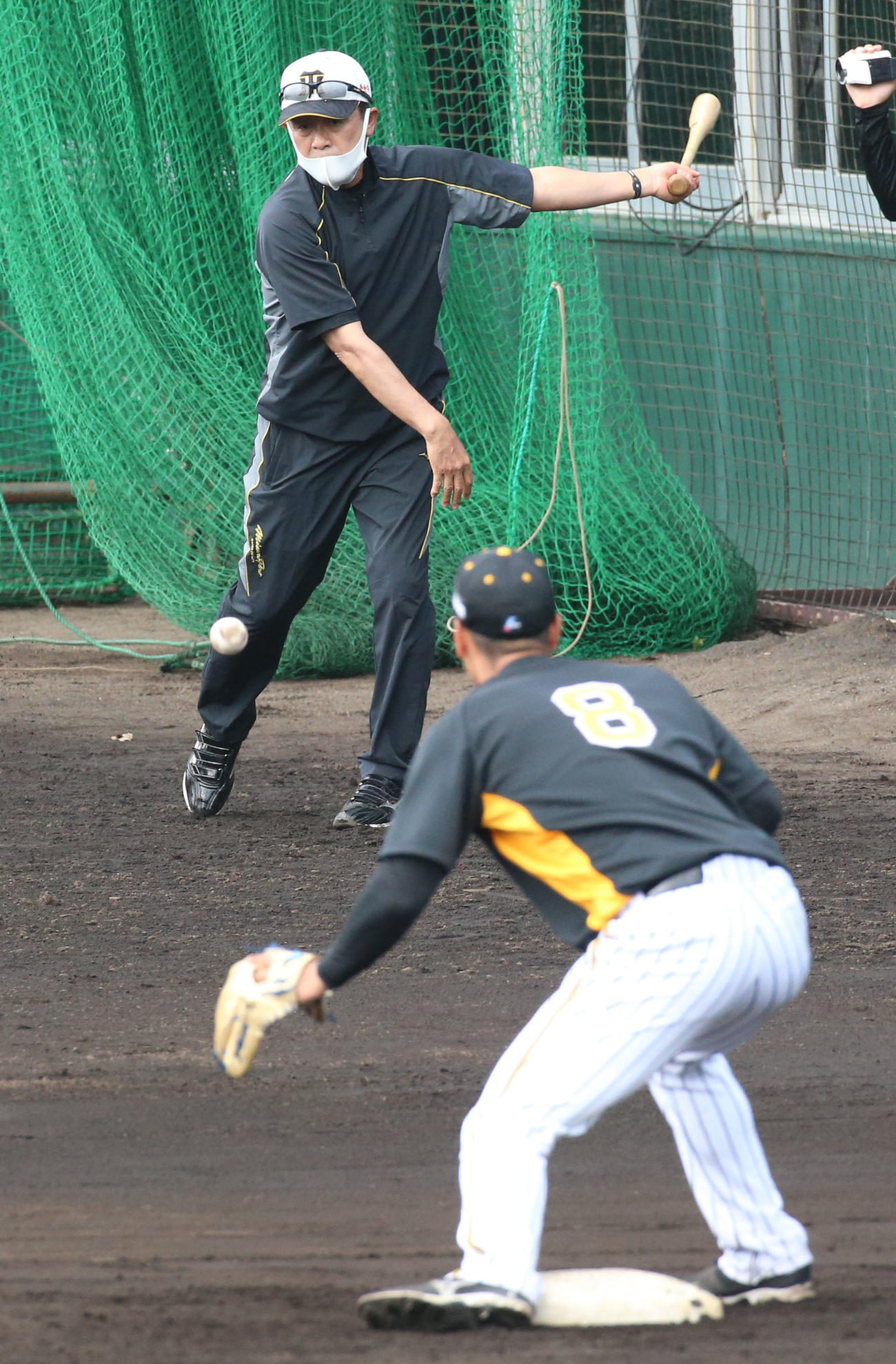 佐藤輝（手前）は三塁ベース上で川相臨時コーチのノックを受ける（撮影・上山淳一）