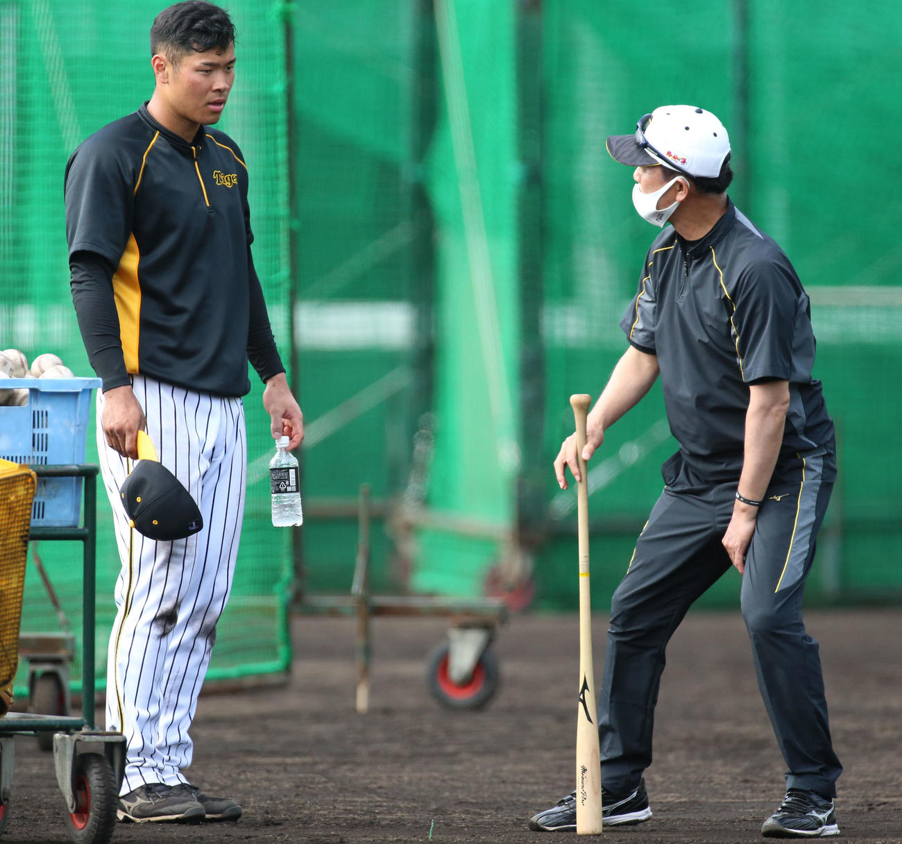 佐藤輝明（左）は川相昌弘臨時コーチの指導を受ける（撮影・上山淳一）